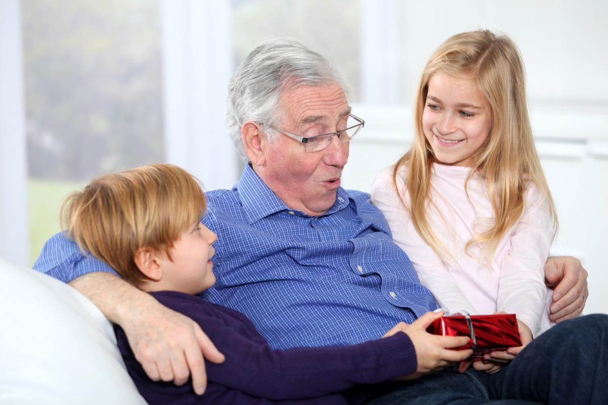 Kids giving birthday gift to their grandfather