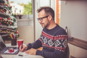 Man writing a Christmas letter.