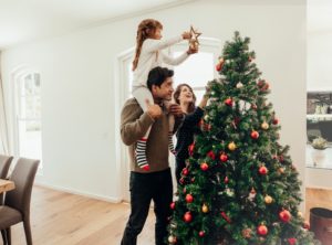 Family Christmas photo in front of their Christmas tree.