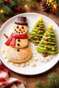 Christmas breakfast snowman pancake with kiwi fruit Christmas trees.